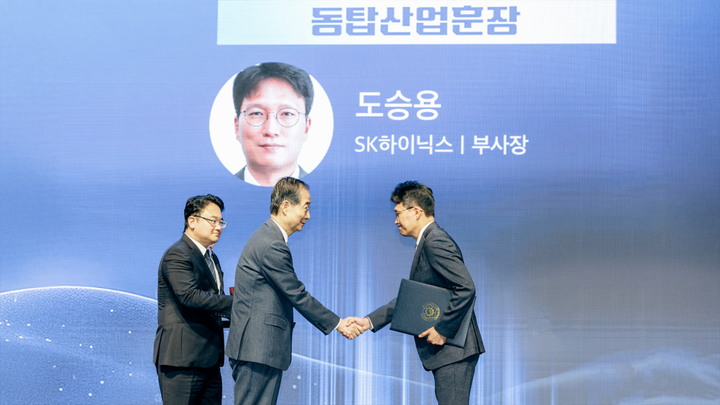 Vice President Doh (right) receiving the Bronze Tower Order of Industrial Service Merit from acting President and Prime Minister Han (center)